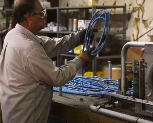 Electrical contractor looking at a spool of wires in a shop.