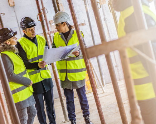 Construction workers discussing blueprint plans