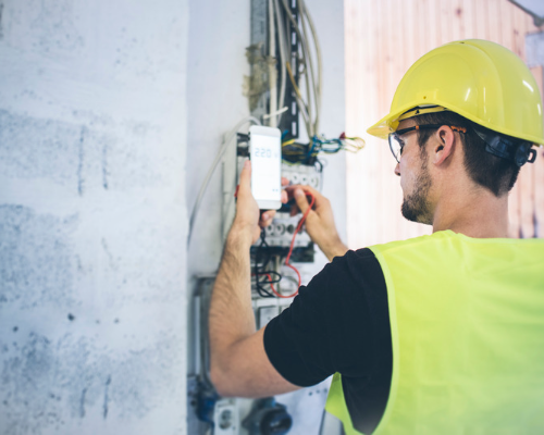 Electrician checking wires on fusebox