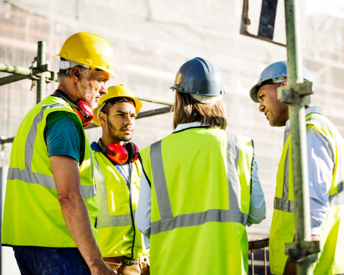 Construction team stood on site, in a circle, chatting